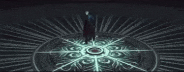 a man in a black robe is standing in front of a circular pattern