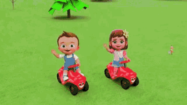 a boy and a girl are riding a red toy car on a grassy field .
