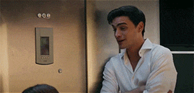 a man in a white shirt is standing next to a woman in a kitchen .