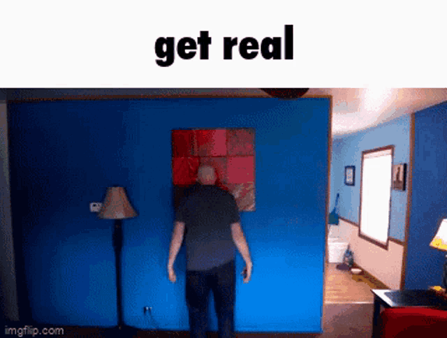 a man is standing in front of a blue wall with the words get real on the top