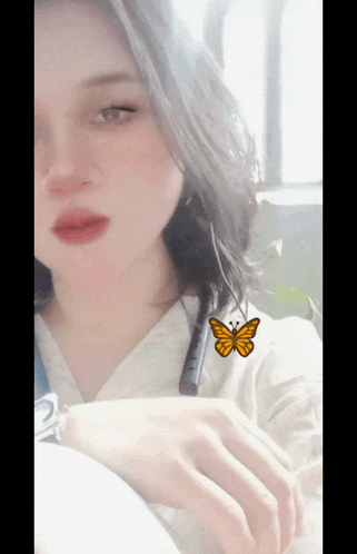 a woman with a butterfly on her neck has a watch on her wrist