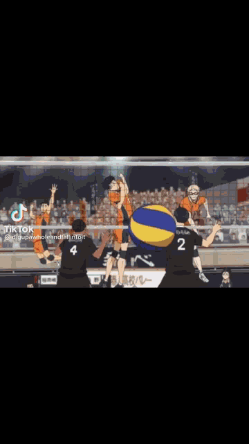 a group of people are playing volleyball on a court with a volleyball in the background .