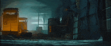 a man is standing in a dark room next to a train .