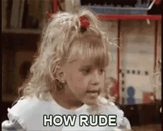a little girl is sitting at a table with the words `` how rude '' on her face .
