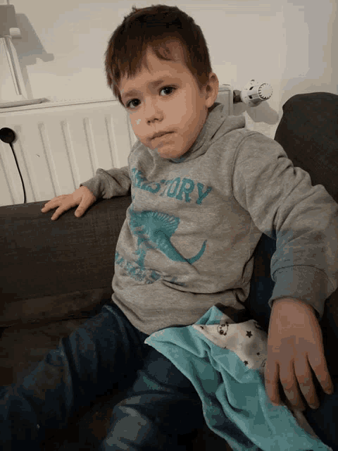 a little boy wearing a grey shirt that says history