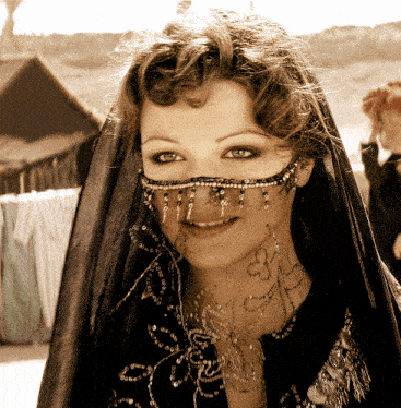 a woman wearing a veil and a necklace with the letter g on her neck
