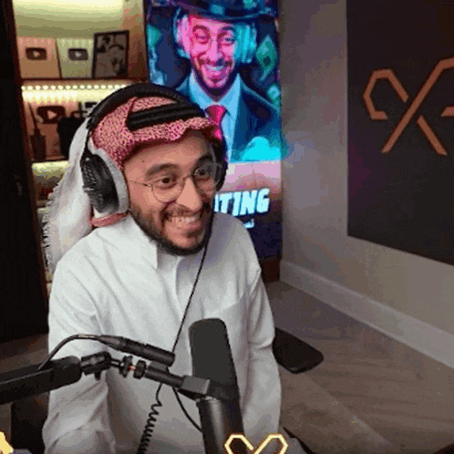 a man wearing headphones is smiling in front of a sign that says ' waiting '