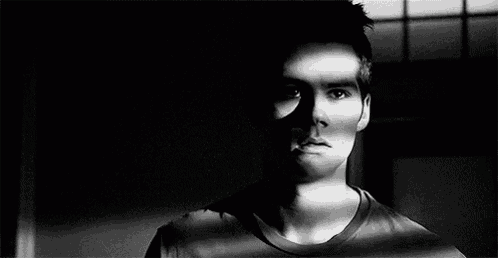 a black and white photo of a man 's face with a shadow on his face .