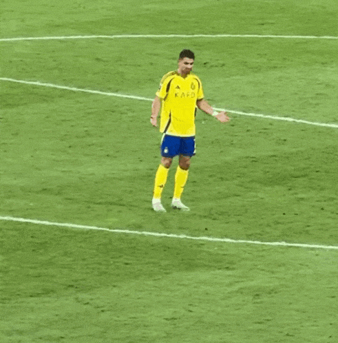 a soccer player wearing a yellow kafc jersey