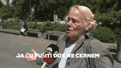 a woman talking into a microphone with the words " ja cu pusiti dok ne ckrnem " behind her