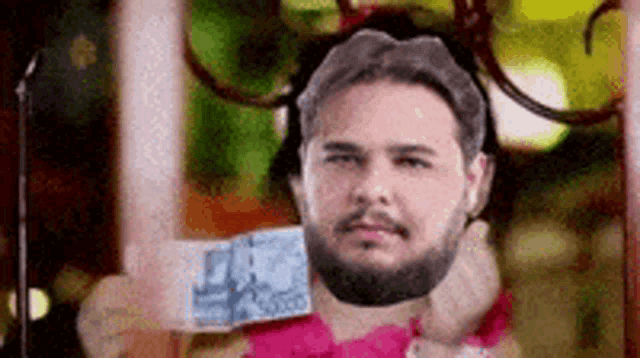 a man with a beard is holding a piece of money in his hand .