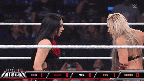 two women in a wrestling ring with a scoreboard behind them that says deadline 1:09