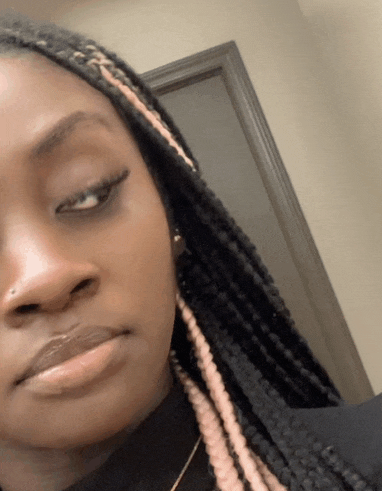 a close up of a woman 's face with braids on her hair