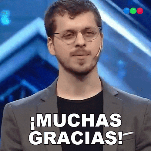 a man wearing glasses says muchas gracias in spanish