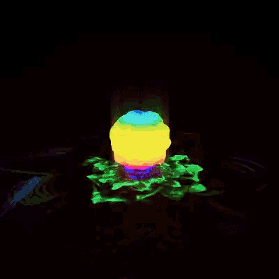 a rainbow colored object is floating on top of a pile of flowers