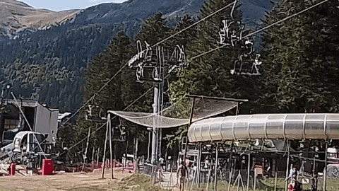 a ski lift is going up a hill with mountains in the background ..