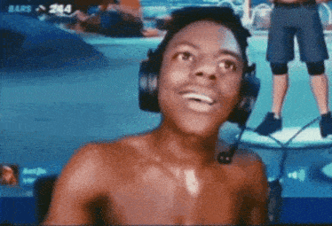 a shirtless man wearing headphones and a microphone in front of a screen that says bars on it
