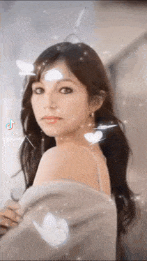 a woman with a butterfly on her forehead is looking at the camera with a tiktok logo in the corner