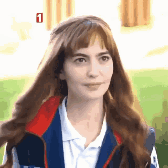 a woman wearing a vest and a white shirt with the number 1 on the bottom right