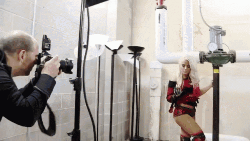 a man is taking a picture of a woman in a red and black outfit