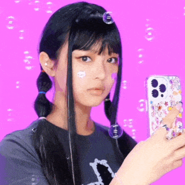 a girl with pigtails is taking a selfie with her cell phone