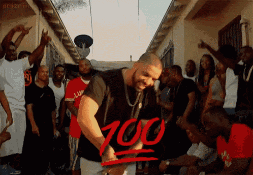 a man in a black shirt is dancing in front of a crowd with a red sign that says ' 100 ' on it