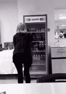 a woman stands in front of a sanyo refrigerator