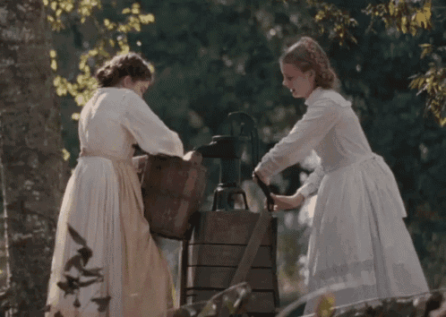 two women in white dresses stand next to each other