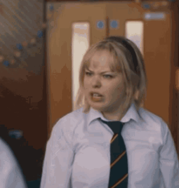 a woman wearing a white shirt and green tie is making a funny face