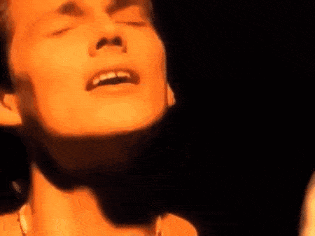 a close up of a woman 's face with her eyes closed and a necklace around her neck .