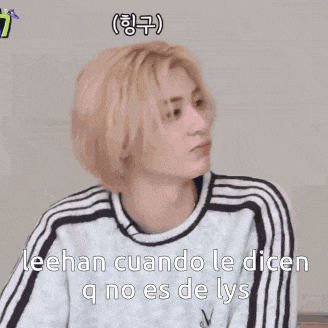 a man with blonde hair is wearing a white sweater with black stripes on the sleeves .