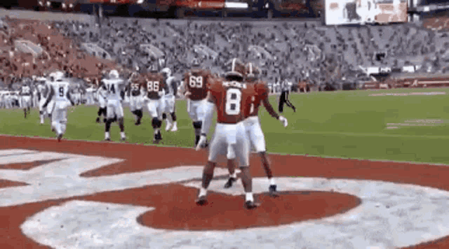 a group of football players are standing on a field .