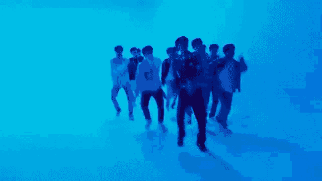 a group of young men are dancing in a purple room .