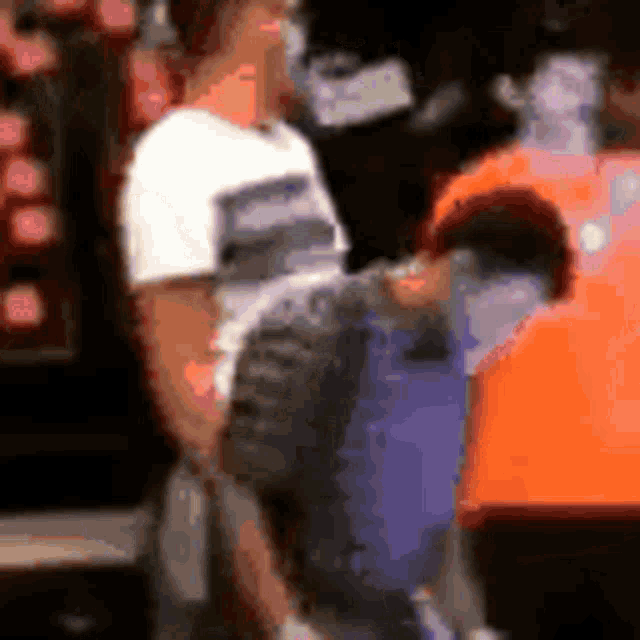 a blurry picture of two men standing next to each other in a room .