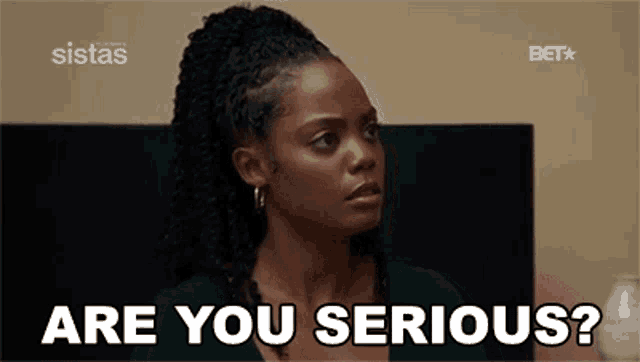 a woman is sitting in front of a television and asking are you serious ?