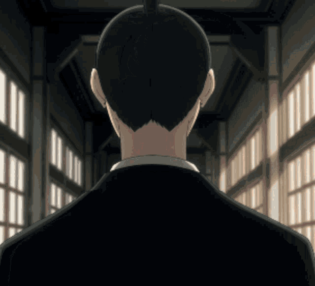 a man in a suit is standing in a hallway with a bun on his head