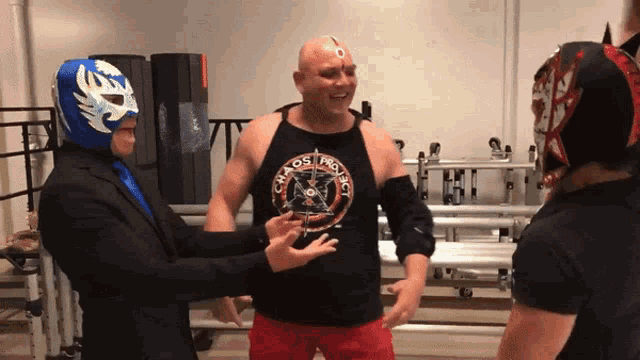 a man wearing a tank top that says kaos wrestling on it