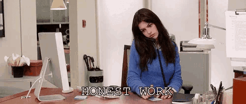 a woman is sitting at a desk in front of a computer with the words honest work written above her