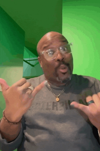 a man wearing glasses and a grey shirt that says caterpillar on it