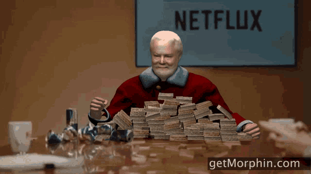 a man is sitting at a table with a pile of money and the words here 's money go