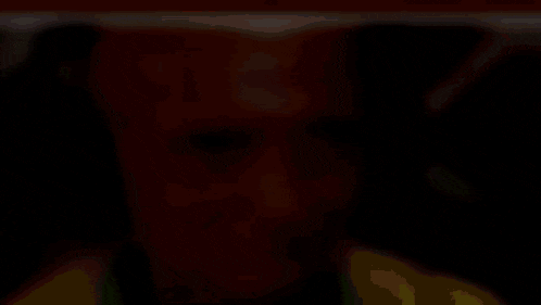 a blurry picture of a man 's face with a yellow shirt