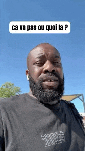 a man with a beard is wearing a black t-shirt and ear buds .
