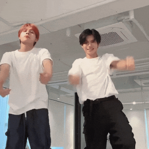 two young men are dancing together in a room with a ceiling fan