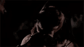 a man and a woman are holding a baby in their arms in the dark .