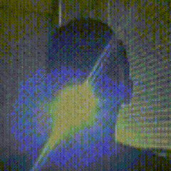 a blurry picture of a person in a dark room with a blue light behind them