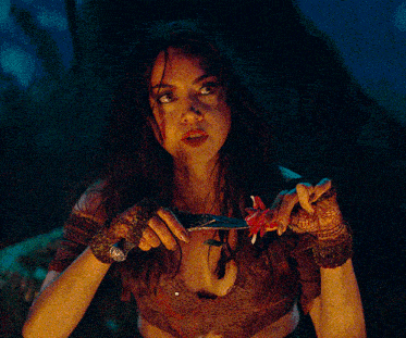 a woman is holding a flower and a knife