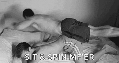 two men are laying on top of each other on a bed with the words `` sit & spin mf er '' written on the bottom .