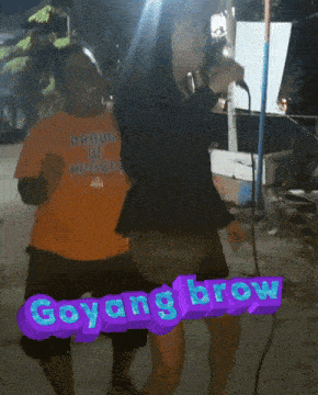 a woman singing into a microphone next to a man wearing an orange shirt that says proud of nigata
