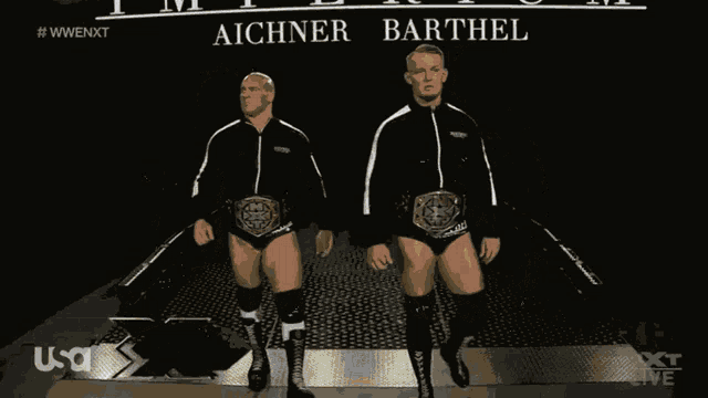 two wrestlers standing in front of a sign that says imperium on it