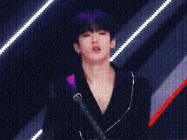 a man with purple hair is wearing a black shirt